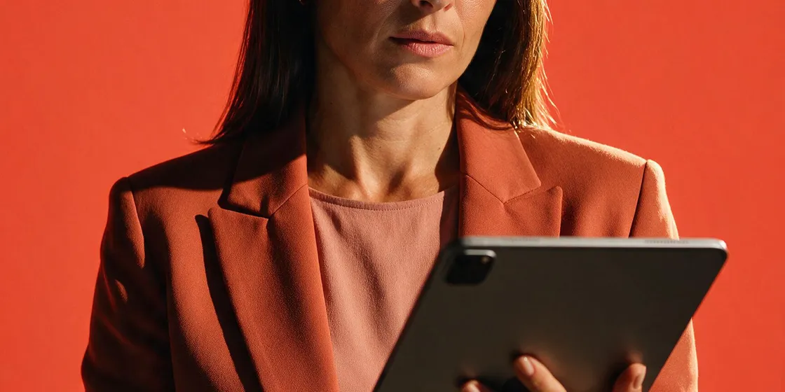 Gestora analisando informações de um sistema de gestão da qualidade em um tablet.