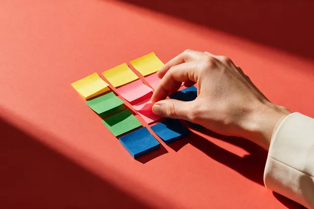 Post-its coloridos organizados em uma matriz para representar a avaliação de riscos na qualidade.